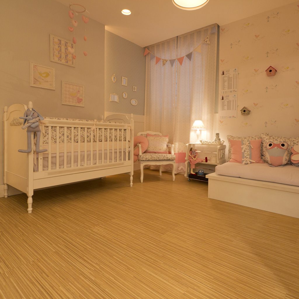 A bright bedroom with pale striped wooden flooring, soft lighting and a white daybed